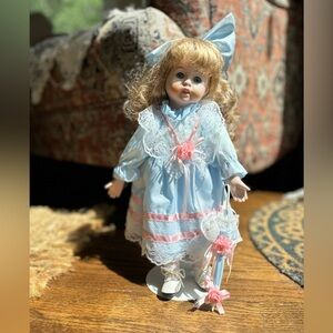 The Heritage Signature Collection porcelain Blue and Pink Doll with Lace Dress